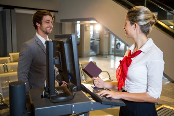 freepicdownloader.com businessman interacting with female airport staff check desk medium