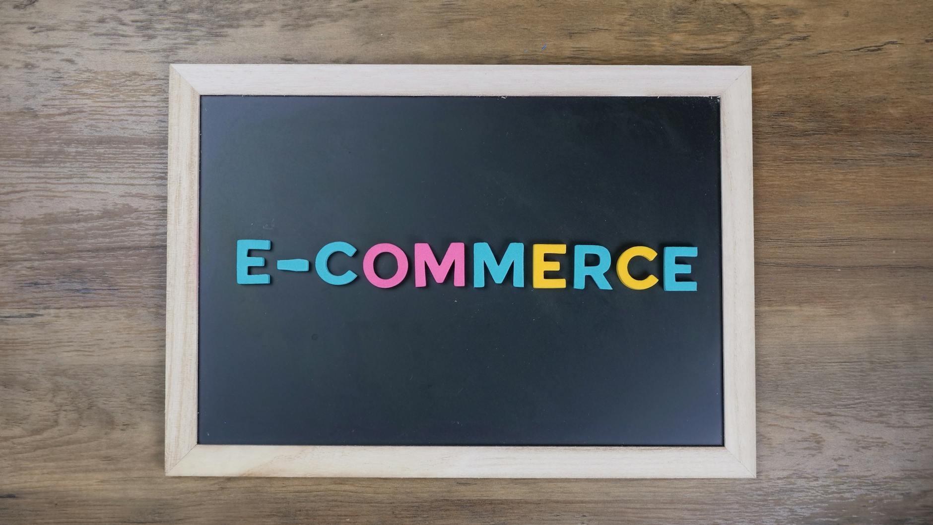 E-Ticaret Yöneticiliği Sertifikası Nasıl Alınır? 1 Colorful letters spelling 'e-commerce' on a wooden framed blackboard.
