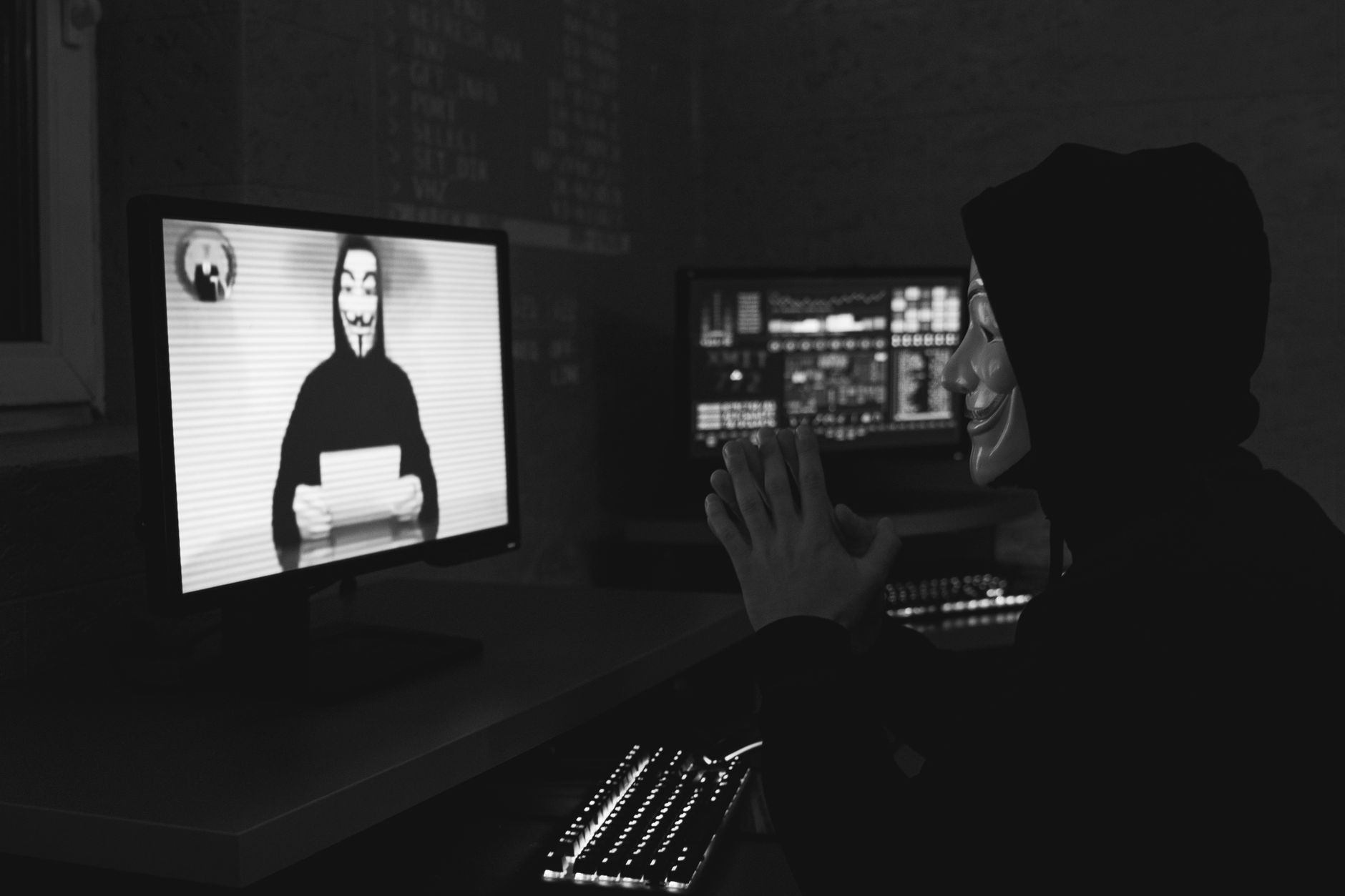 Online Etik Hacker Eğitimi Nasıl Alınır? 1 Monochrome image of a masked hacker on a video call, showcasing cyber security themes.