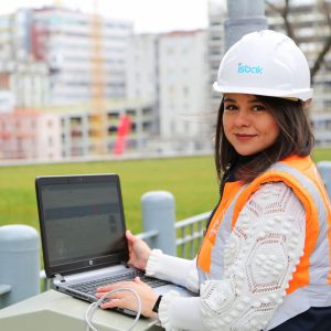 A female engineer using a laptop at a construction site outdoors.