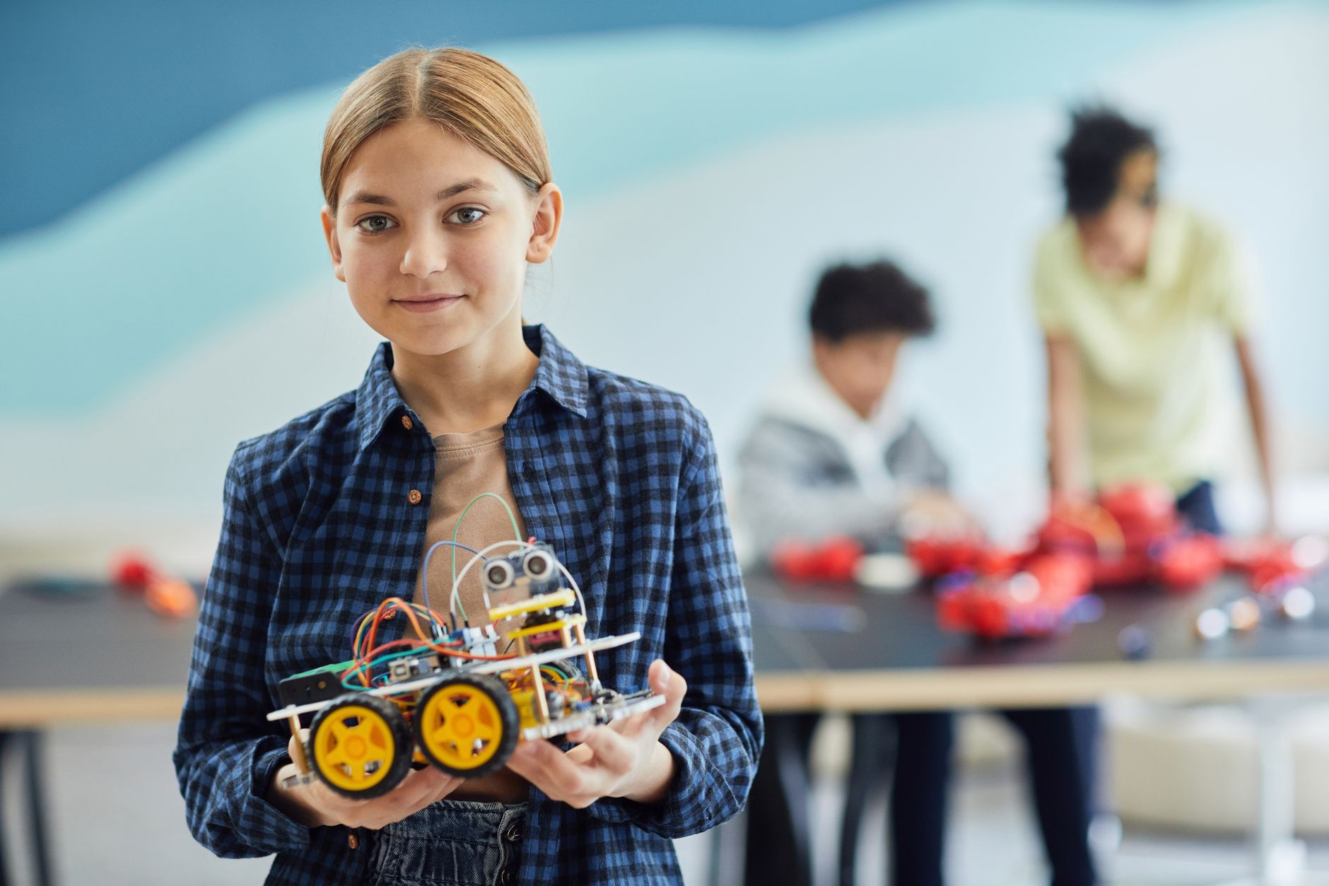 ROBOTİK KODLAMA EĞİTİMİ Sertifikası 1 Girl proudly displays her robotics project in a classroom setting.