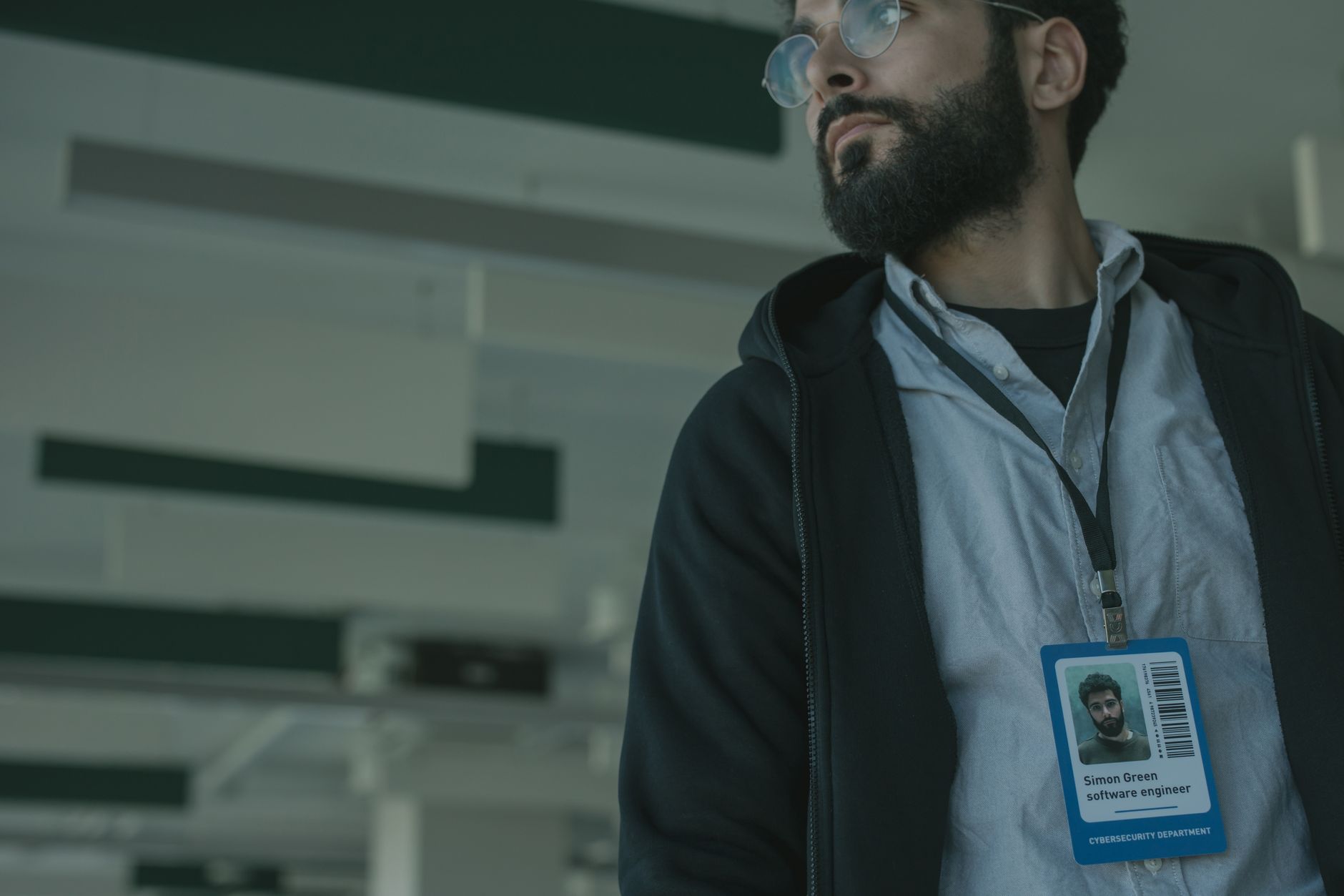 Sistem Güvenliği Uzmanı Nasıl Olunur? 1 Male software engineer with glasses and name badge in a contemporary office interior.