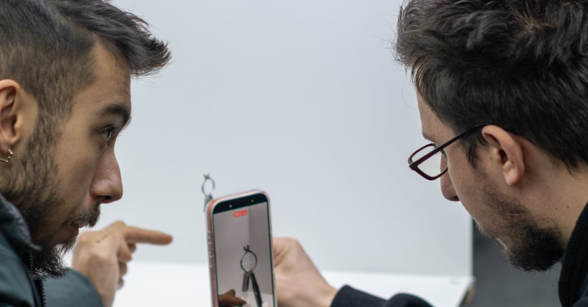 Sosyal Medya Reklam Uzmanı Nasıl Olunur? 1 İki genç adam, kapalı bir alanda telefon kurulumunu incelerken fotoğrafçılık teknikleri hakkında konuşuyorlardı.