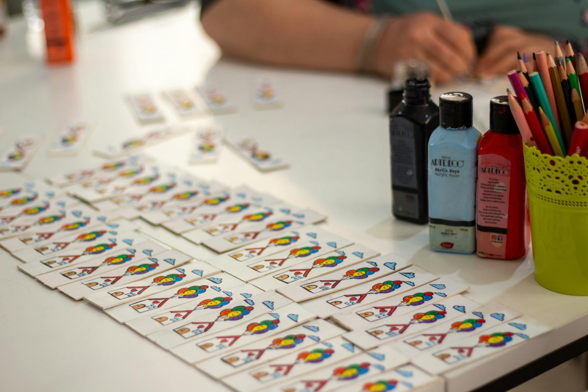 YAPILANDIRILMIŞ OYUN TERAPİSİ EĞİTİMİ Sertifikası 1 Creative workspace featuring paints, playing cards, and colored pencils, ideal for arts and crafts themes.