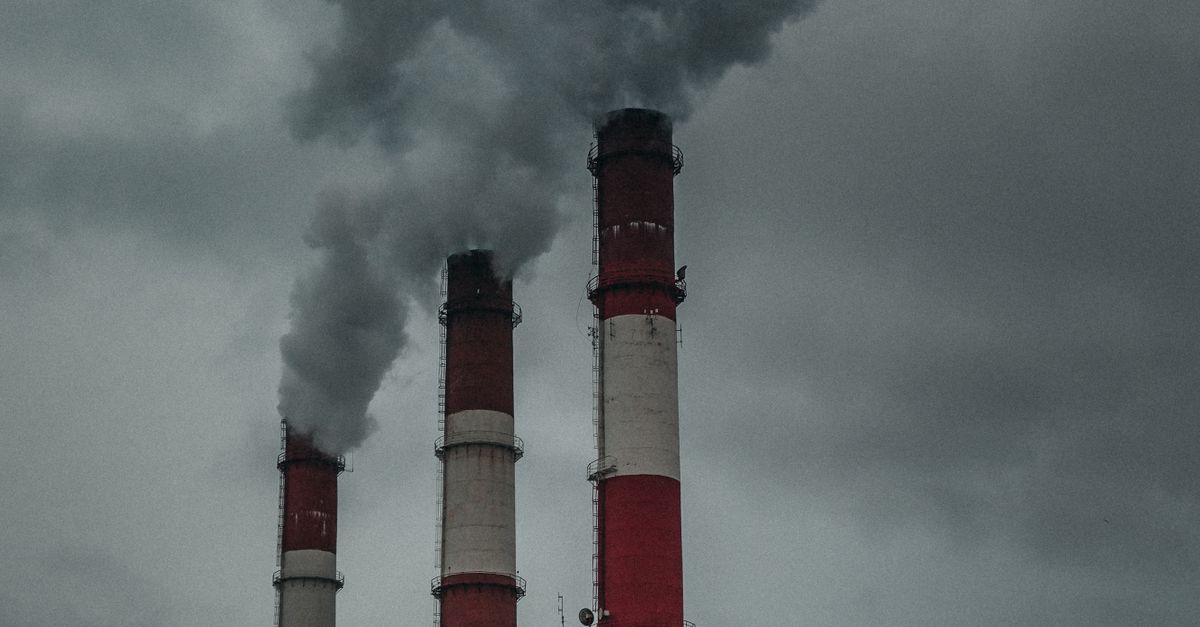ISO 14064 Nedir? Karbon Ayak İzi Hesaplama ve Doğrulama Süreci 1 Üç sanayi bacası, kapalı bir gökyüzüne duman salarak çevre kirliliğini vurguluyor.